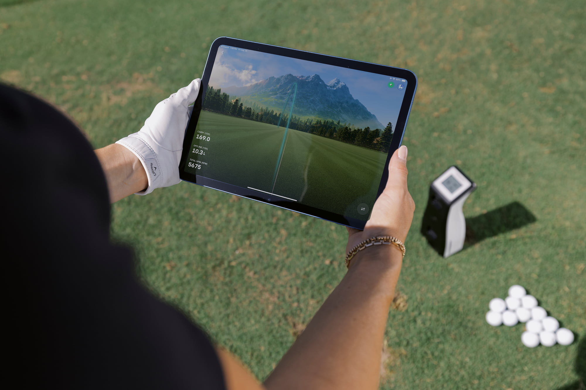 Golfer holding a tablet above the GC2